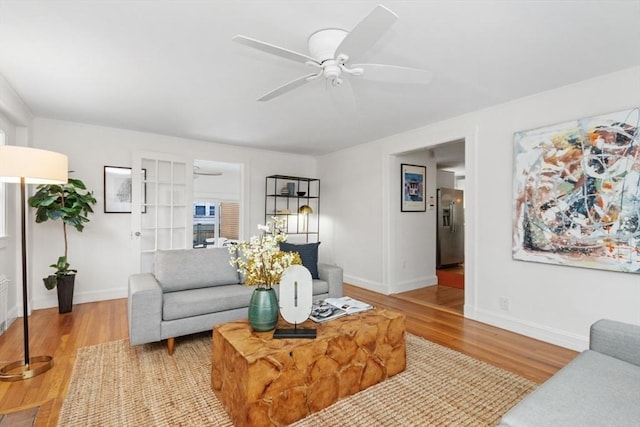 living room with ceiling fan and light wood-type flooring