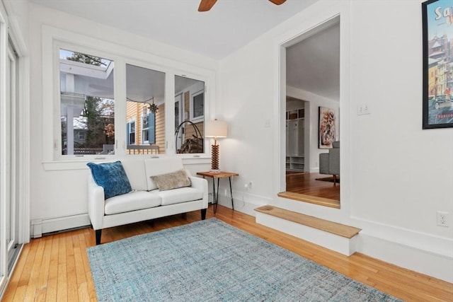 sitting room with hardwood / wood-style flooring, ceiling fan, and a baseboard heating unit