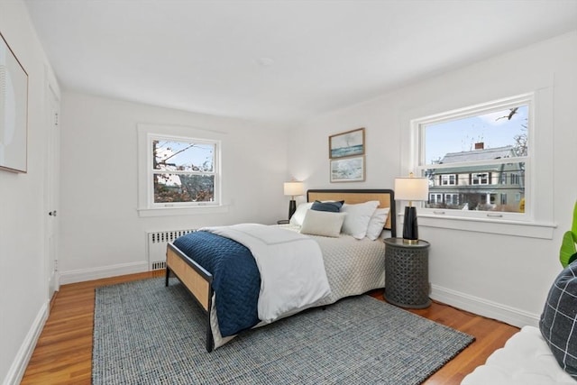 bedroom with wood-type flooring and radiator heating unit