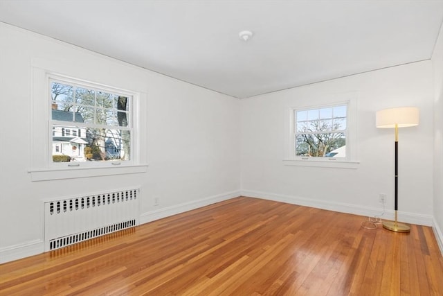 unfurnished room with wood-type flooring and radiator