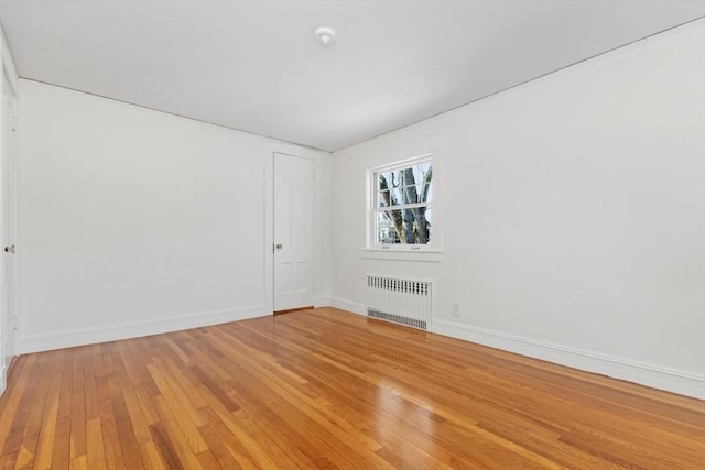 spare room featuring hardwood / wood-style flooring and radiator heating unit