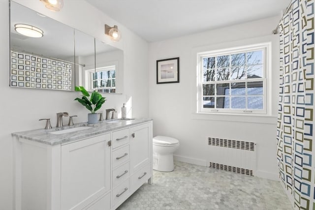 bathroom with vanity, radiator, and toilet