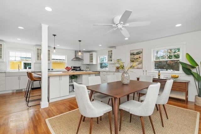 dining area featuring sink, ceiling fan, and light wood-type flooring