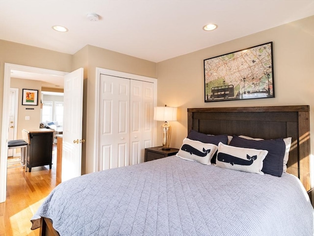 bedroom with light hardwood / wood-style floors and a closet