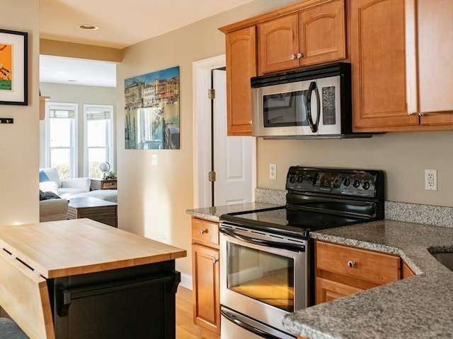 kitchen with butcher block counters, light wood-type flooring, and appliances with stainless steel finishes