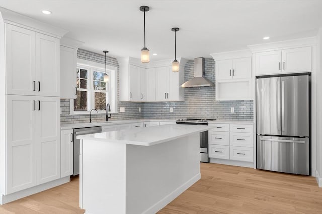 9 Patten Rd, Norton, MA 02766 - kitchen with appliances with stainless steel finishes, wall chimney exhaust hood, white cabinets, decorative backsplash, and light wood-type flooring