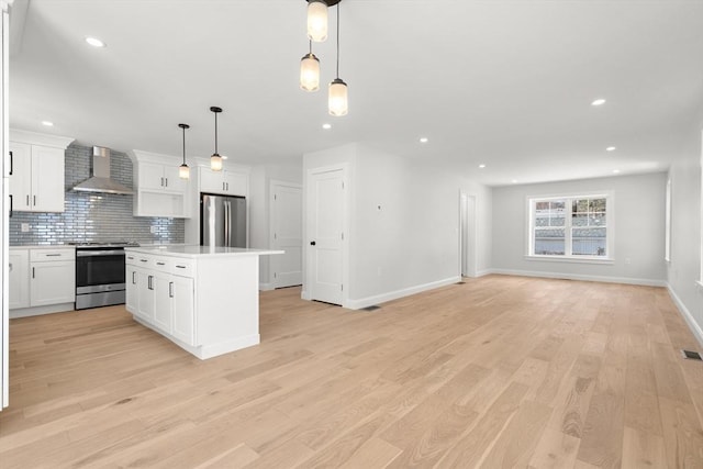 9 Patten Rd, Norton, MA 02766 - kitchen with appliances with stainless steel finishes, wall chimney range hood, tasteful backsplash, a center island, and open floor plan