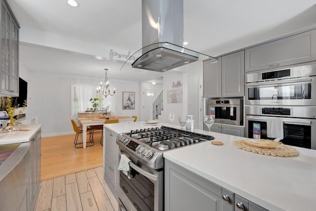 45 Olney Ave, Springfield, MA 01119 - kitchen with stainless steel appliances, gray cabinets, island range hood, a chandelier, and recessed lighting