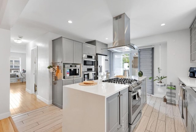 45 Olney Ave, Springfield, MA 01119 - kitchen featuring appliances with stainless steel finishes, gray cabinetry, island range hood, a kitchen island, and recessed lighting