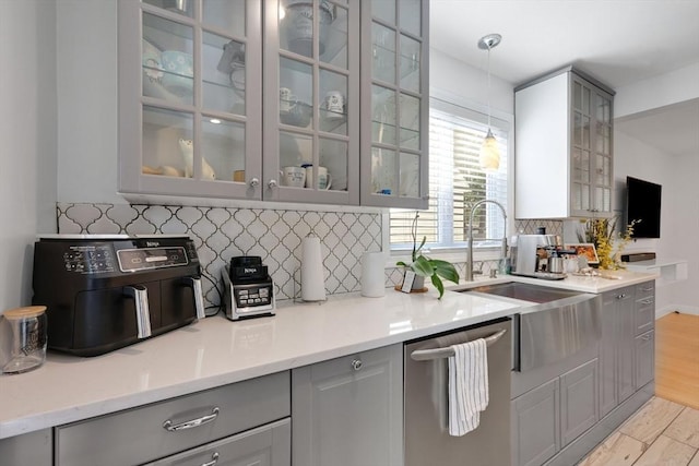 45 Olney Ave, Springfield, MA 01119 - kitchen featuring gray cabinetry, stainless steel dishwasher, tasteful backsplash, glass insert cabinets, and hanging light fixtures