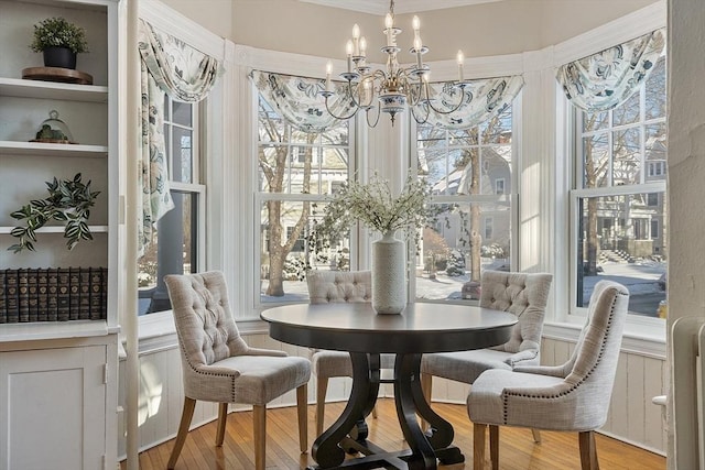 dining space with light hardwood / wood-style flooring and a notable chandelier