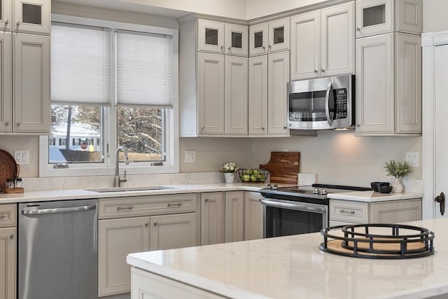 kitchen featuring sink, stainless steel appliances, and light stone counters