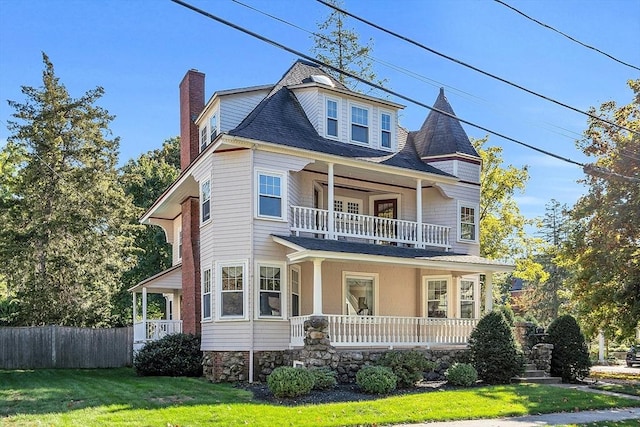 victorian home featuring a balcony, a front yard, and a porch