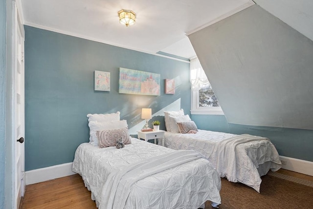 bedroom featuring hardwood / wood-style floors, lofted ceiling, and ornamental molding