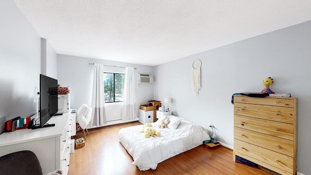 10 Williams St Unit 26, Watertown, MA 02472 - bedroom with light wood finished floors, a wall mounted air conditioner, and baseboards