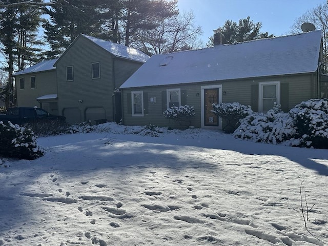 snow covered property with a garage