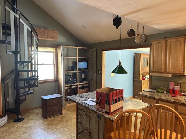 kitchen with vaulted ceiling, a kitchen island, decorative light fixtures, dark stone counters, and light parquet flooring