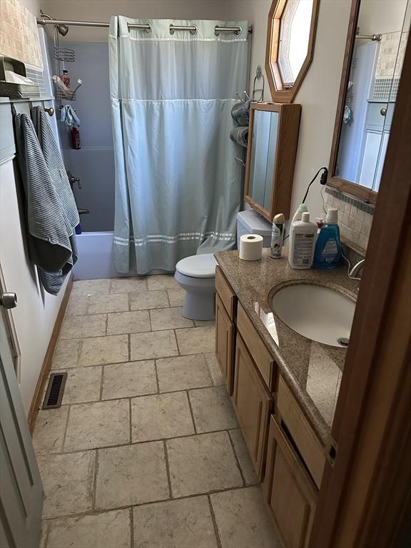 full bathroom featuring vanity, toilet, and shower / bath combo