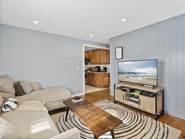 living room featuring light wood finished floors, baseboards, and recessed lighting