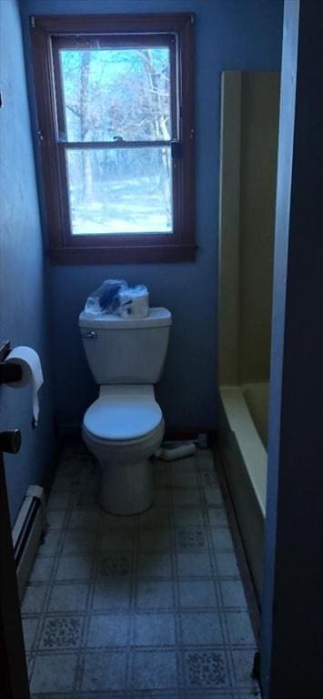 bathroom featuring a baseboard radiator, a washtub, and toilet