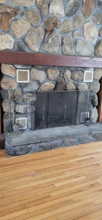 interior details with hardwood / wood-style flooring and a stone fireplace