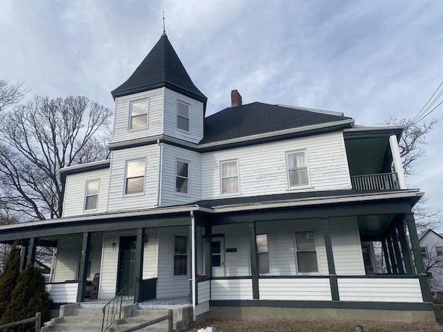 victorian home with covered porch, a shingled roof, a chimney, and a balcony