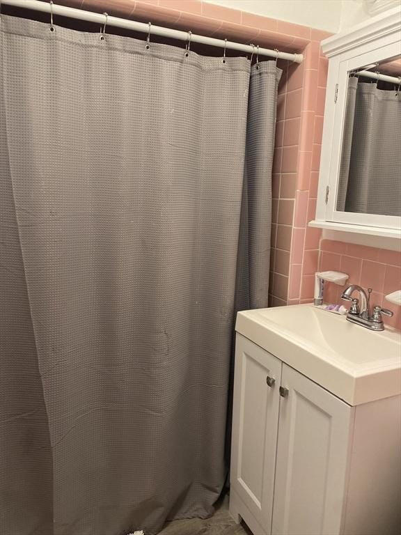 bathroom with tasteful backsplash, vanity, tile walls, and a shower with curtain