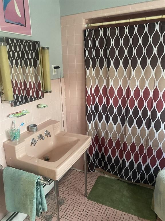 bathroom with tile walls, a shower with shower curtain, and tile patterned floors