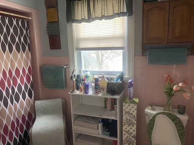 bathroom with tile walls and a shower with shower curtain