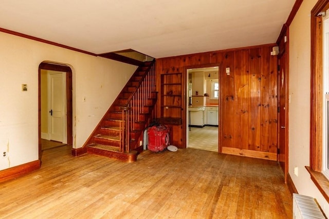326 Lake Rd, Ashburnham, MA 01430 - unfurnished living room featuring arched walkways, stairway, wood finished floors, crown molding, and radiator