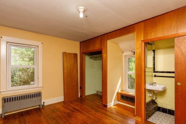 326 Lake Rd, Ashburnham, MA 01430 - unfurnished bedroom with radiator, hardwood / wood-style floors, connected bathroom, a closet, and wooden walls