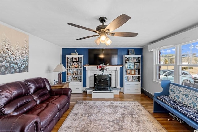 living area featuring baseboards, crown molding, a ceiling fan, and wood finished floors