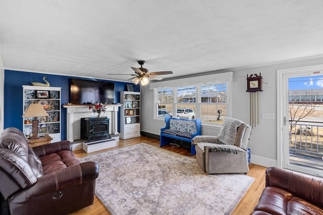 living room featuring a ceiling fan, wood finished floors, baseboards, and a textured ceiling