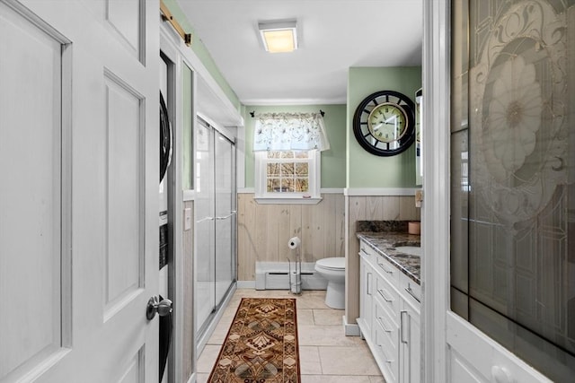 full bathroom featuring vanity, a stall shower, wainscoting, toilet, and baseboard heating