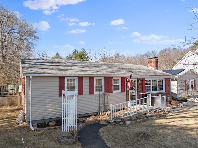 view of front of home featuring a chimney and fence