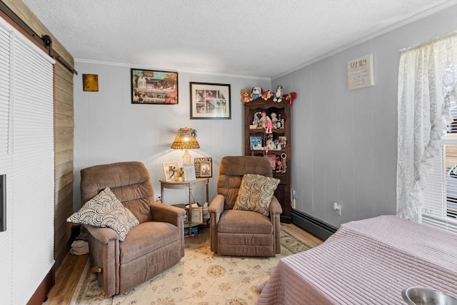 bedroom featuring a textured ceiling, a baseboard heating unit, a barn door, and wood finished floors