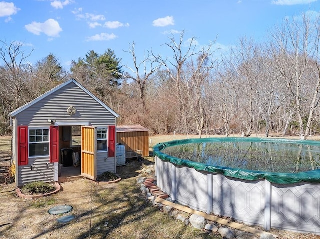 view of swimming pool with a covered pool and an outbuilding