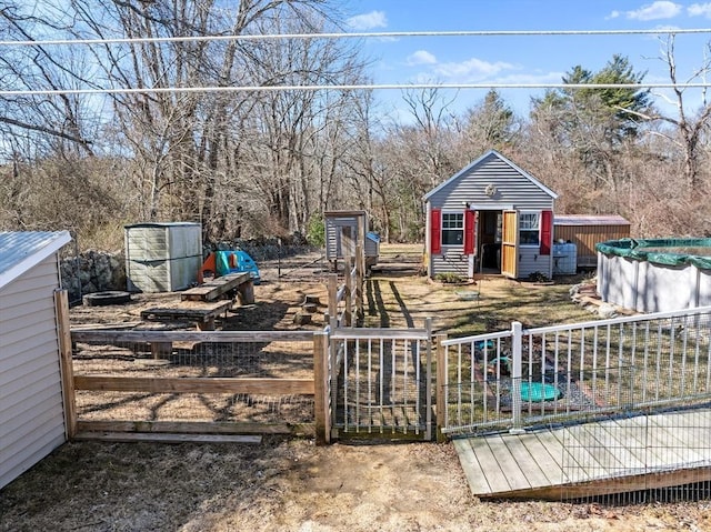 view of yard with fence, an outdoor structure, and a gate