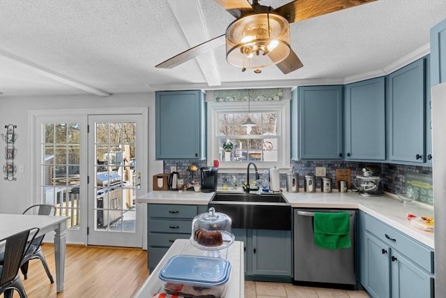 kitchen with a sink, blue cabinets, plenty of natural light, and dishwasher