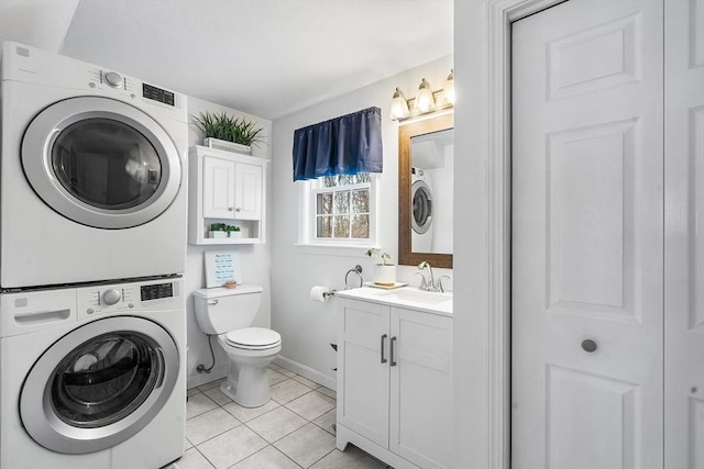 bathroom featuring vanity, stacked washer / drying machine, tile patterned floors, and toilet