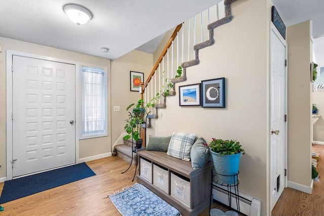 foyer entrance featuring a baseboard heating unit and hardwood / wood-style flooring