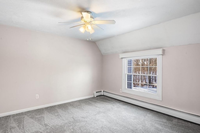 spare room featuring baseboard heating, ceiling fan, carpet flooring, and vaulted ceiling