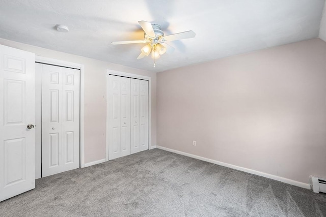 unfurnished bedroom featuring ceiling fan, carpet flooring, and two closets