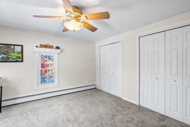 unfurnished bedroom featuring ceiling fan, a baseboard radiator, light colored carpet, and multiple closets