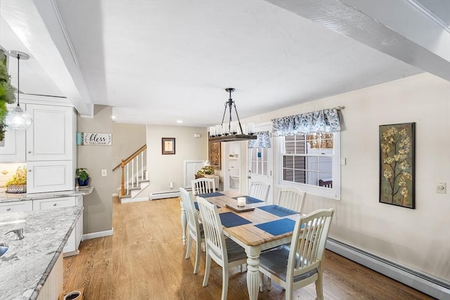 dining room featuring a baseboard radiator and light hardwood / wood-style flooring