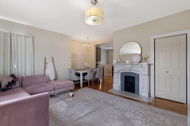34 Warren St Unit 3, Stoneham, MA 02180 - living area with wood finished floors, a chandelier, and a fireplace with raised hearth