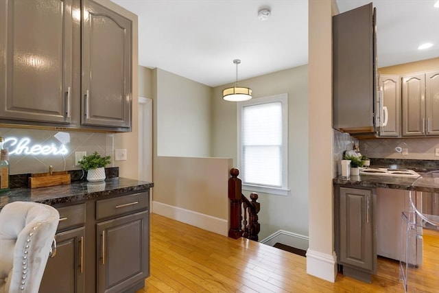 34 Warren St Unit 3, Stoneham, MA 02180 - kitchen featuring backsplash, light wood-type flooring, pendant lighting, dark stone countertops, and recessed lighting