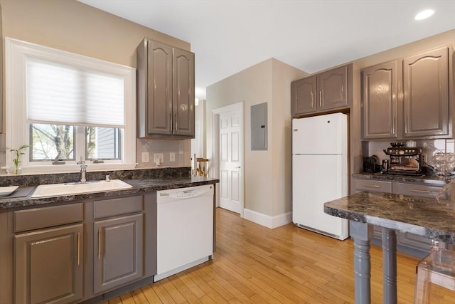 34 Warren St Unit 3, Stoneham, MA 02180 - kitchen with white appliances, electric panel, dark countertops, light wood-style flooring, and tasteful backsplash