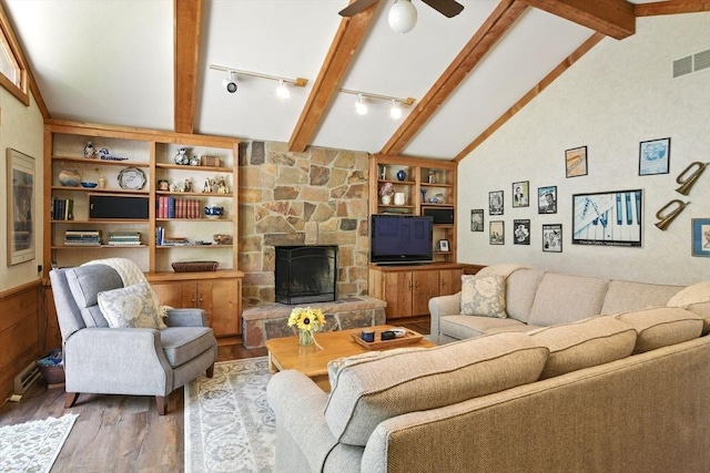 living room featuring track lighting, visible vents, wood finished floors, lofted ceiling with beams, and a ceiling fan