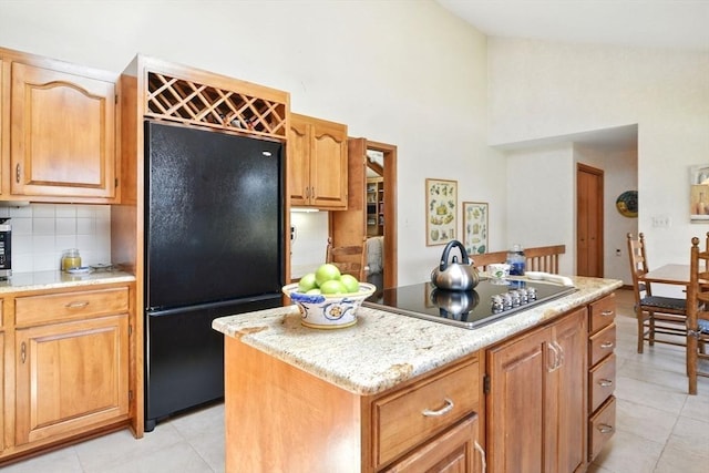 kitchen with light tile patterned floors, high vaulted ceiling, a kitchen island, and black appliances